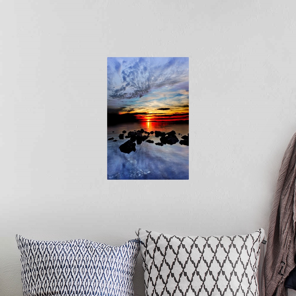 A bohemian room featuring Blue clouds reflected in the sea in the red sunset landscape.