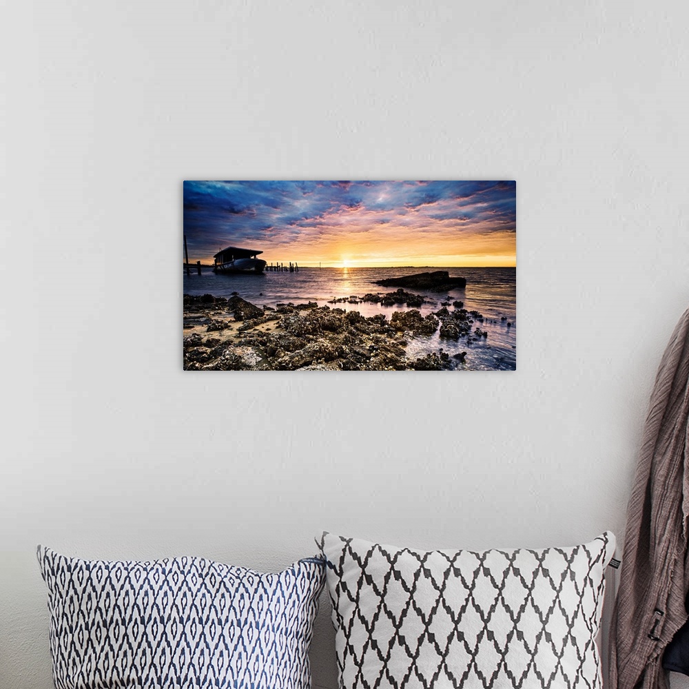 A bohemian room featuring Barnacle covered shore shipwreck at sunrise on the beach.