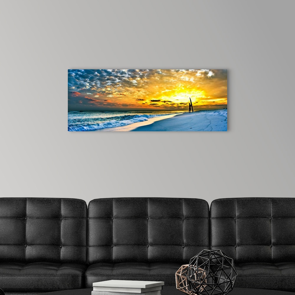 A modern room featuring A surfer stands with his board before a bright orange sunset in this inspirational image. Landsca...