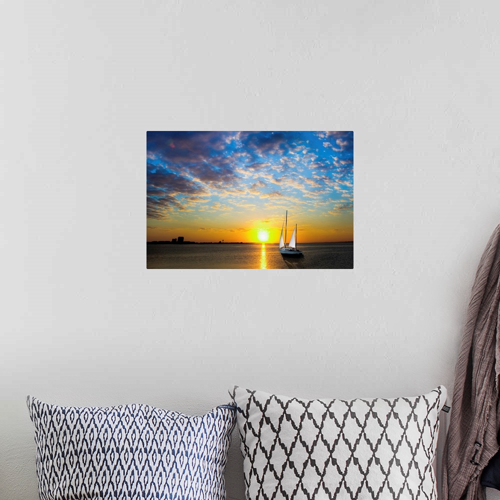 A bohemian room featuring A sailboat sailing into the sun under a blue sky.