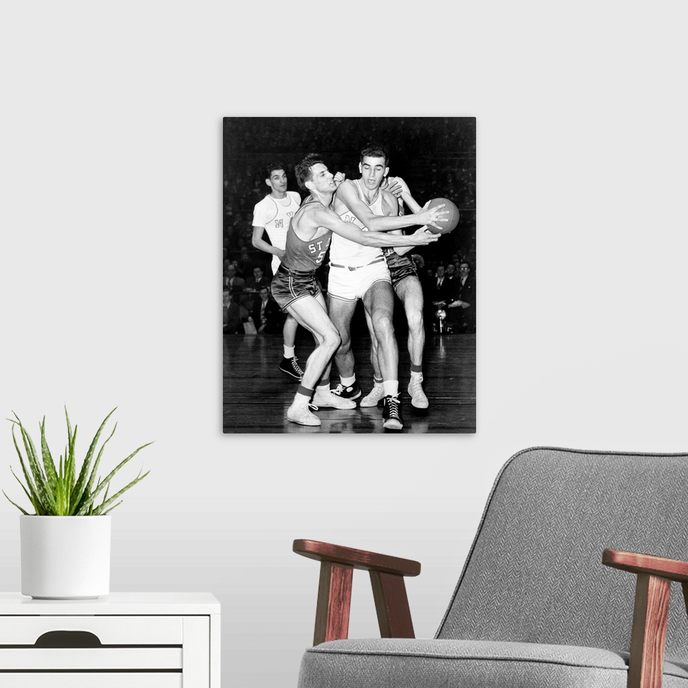 A modern room featuring Adolph 'Dolph' Schayes keeping the basketball away from Joe Ossola of St. Louis University, 1948....