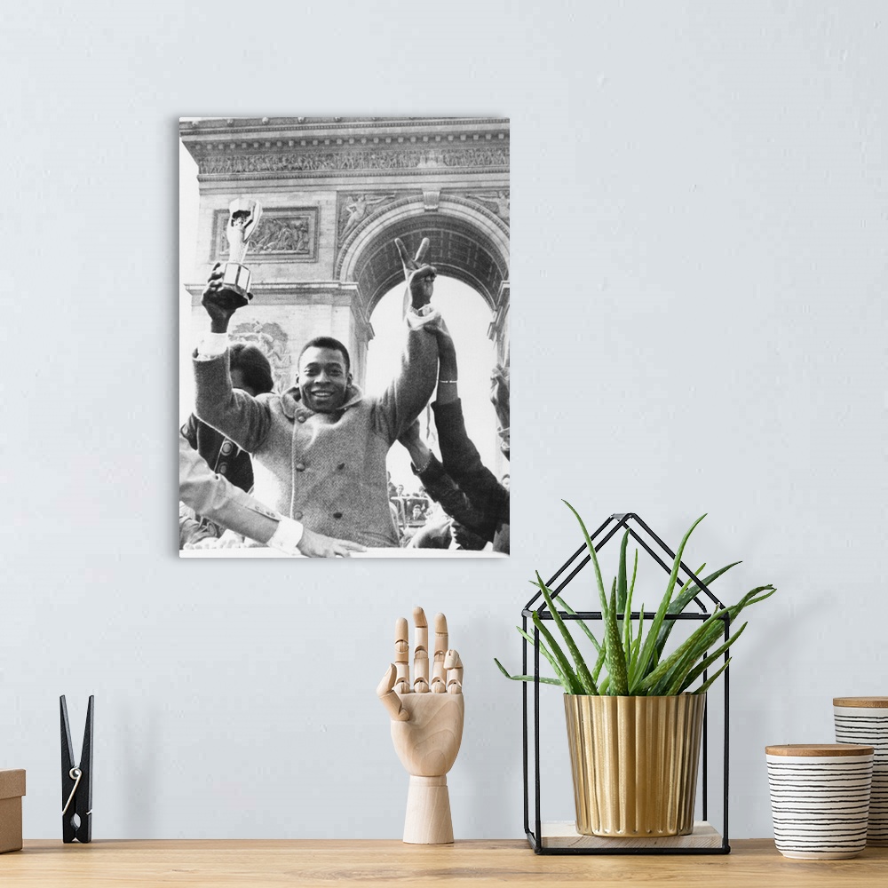 A bohemian room featuring Brazilian soccer star Pele waves the Jules Rimet Cup from an open car on Paris' Champs Elysees. M...