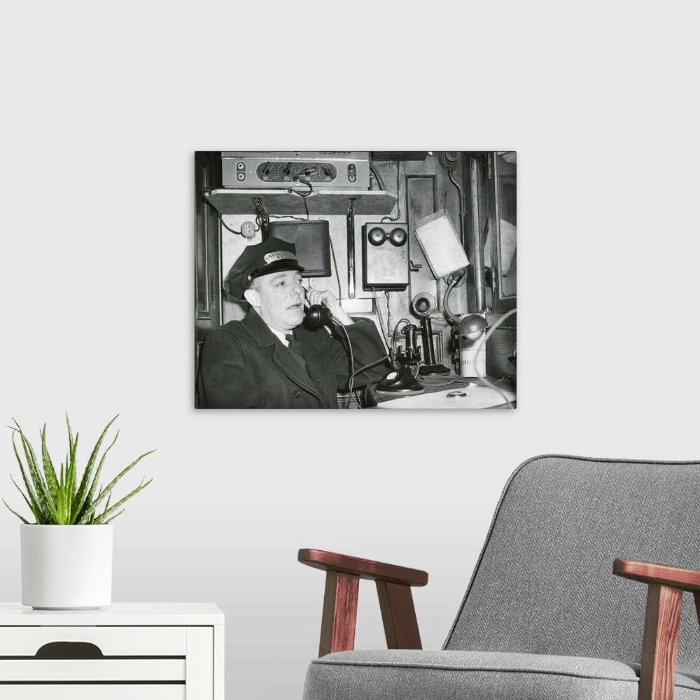 A modern room featuring Railroad conductor uses an on board telephone to communicate with other parts of the train. c. 19...