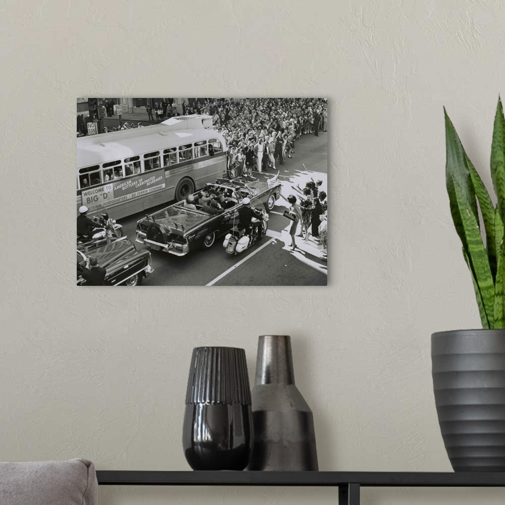 A modern room featuring Dallas crowds waving as President Kennedy's limousine drives through downtown Dallas. Texas Gover...