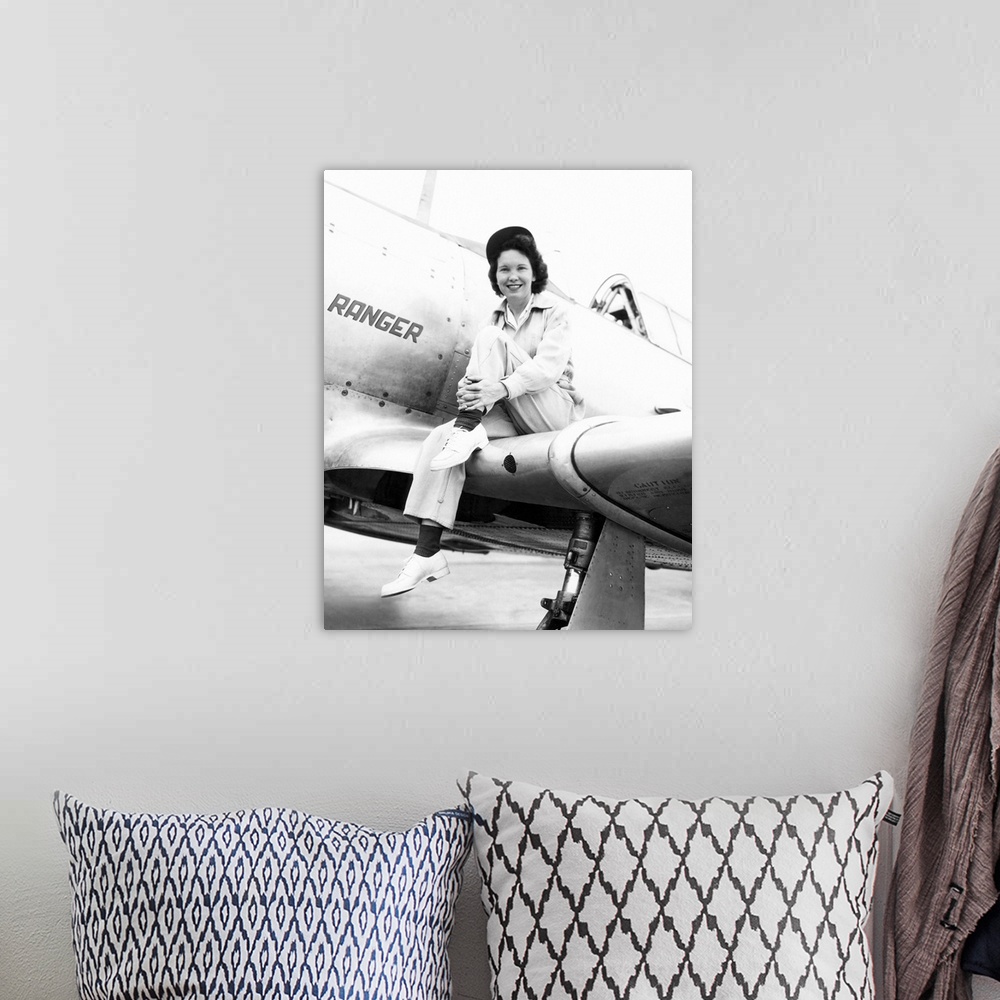 A bohemian room featuring Margaret (Mickey) McGrath, former WASP sitting on the wing of in an XAT-6E trainer aircraft. It w...