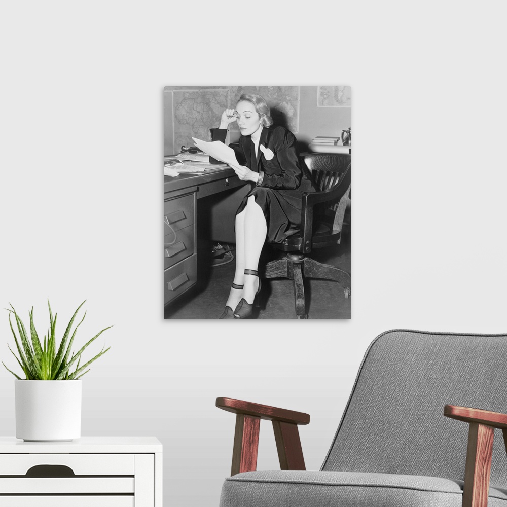 A modern room featuring Marlene Dietrich in her office at the U.S. War Department, Bureau of Public Relations, May 1942. ...