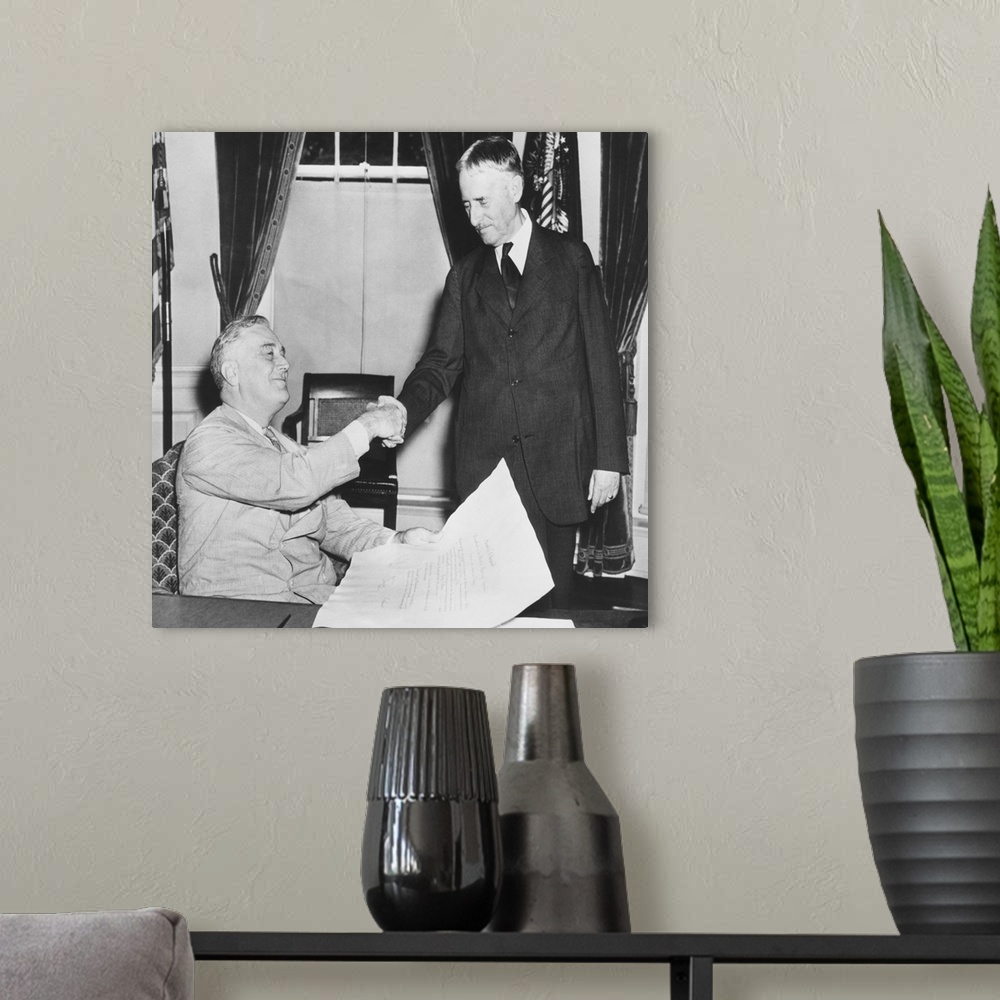 A modern room featuring President Franklin Roosevelt shaking hands with his new Secretary of War, Republican Henry Stimso...
