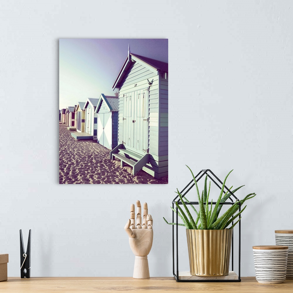 A bohemian room featuring Slightly faded photograph of a row of colorful beach cottages right on the sand.