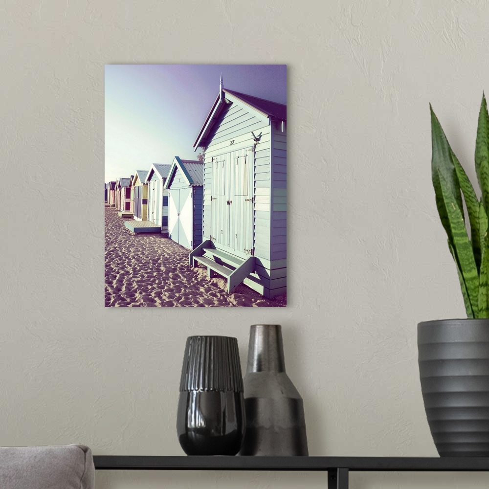 A modern room featuring Slightly faded photograph of a row of colorful beach cottages right on the sand.