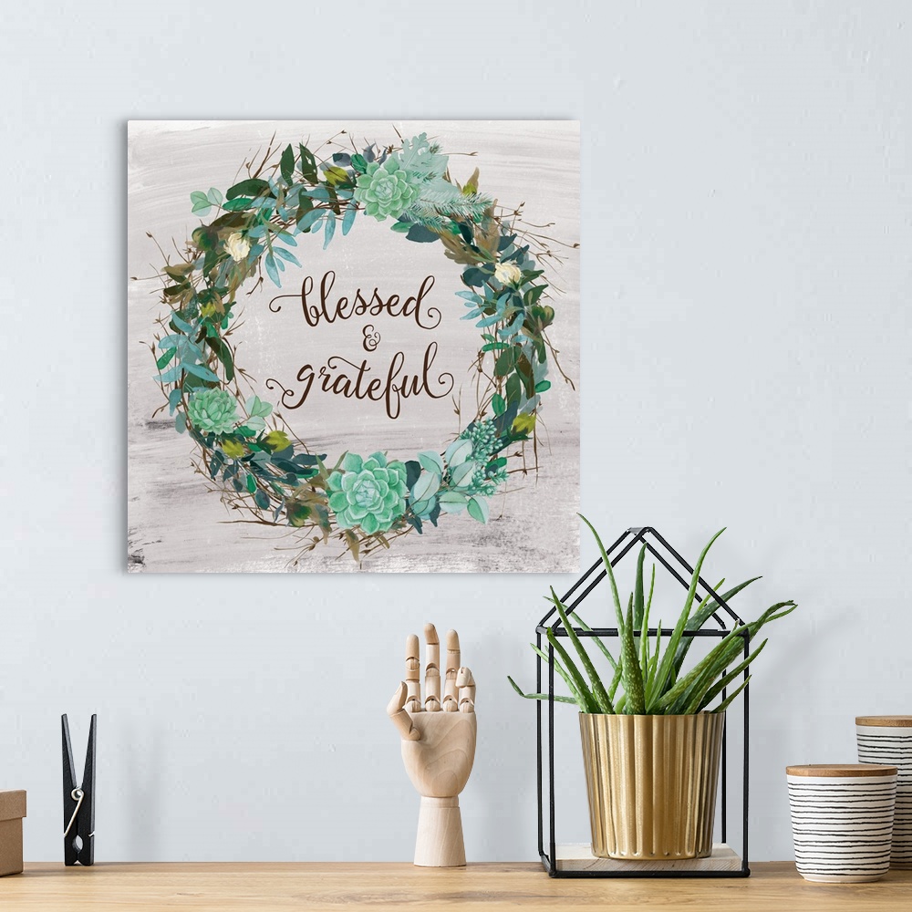 A bohemian room featuring "Blessed and Grateful" written inside a wreath made of greenery and succulents with a few small f...