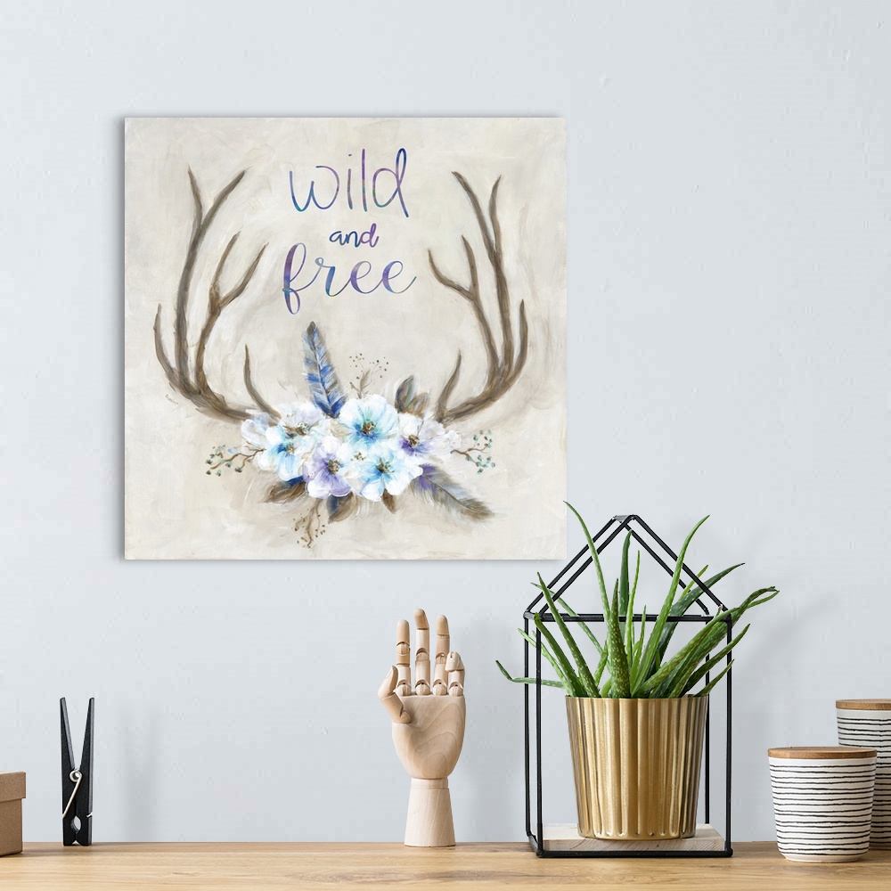 A bohemian room featuring Square painting of antlers decorated with flowers and feathers and has the phrase "Wild and Free"...