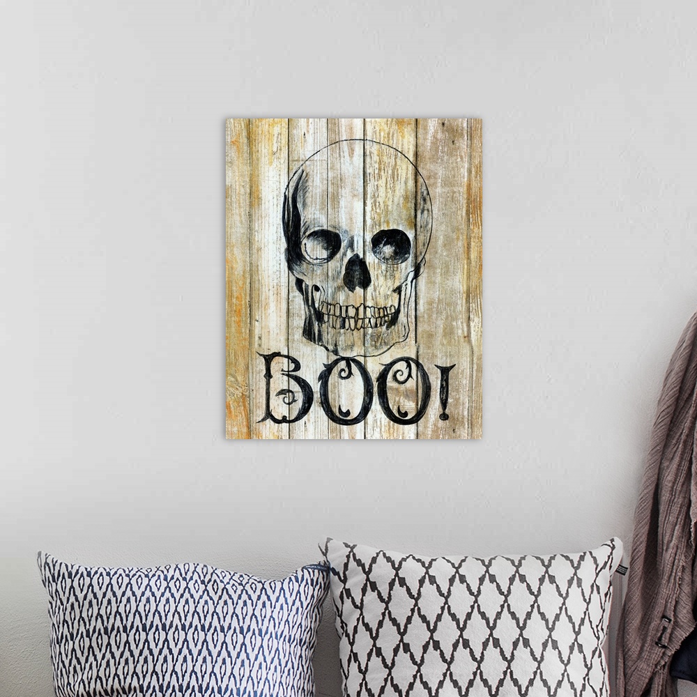 A bohemian room featuring A painting of a skull on a wooden background with the word ?BOO!? underneath.�
