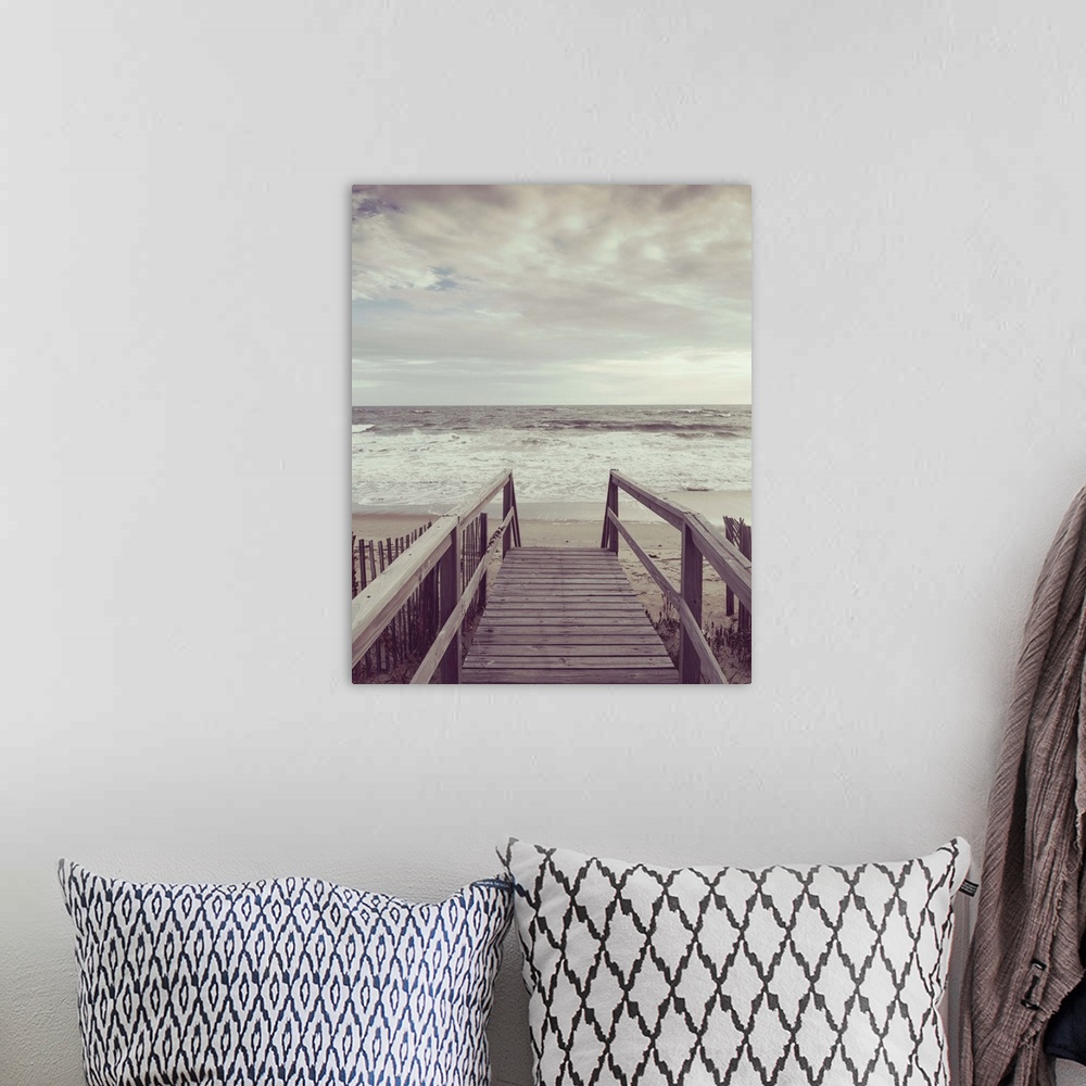 A bohemian room featuring Photograph, with a faded look, of a wooden boardwalk that leads to the ocean shore.