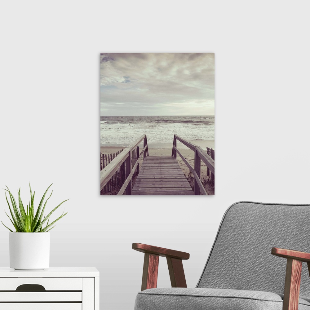 A modern room featuring Photograph, with a faded look, of a wooden boardwalk that leads to the ocean shore.