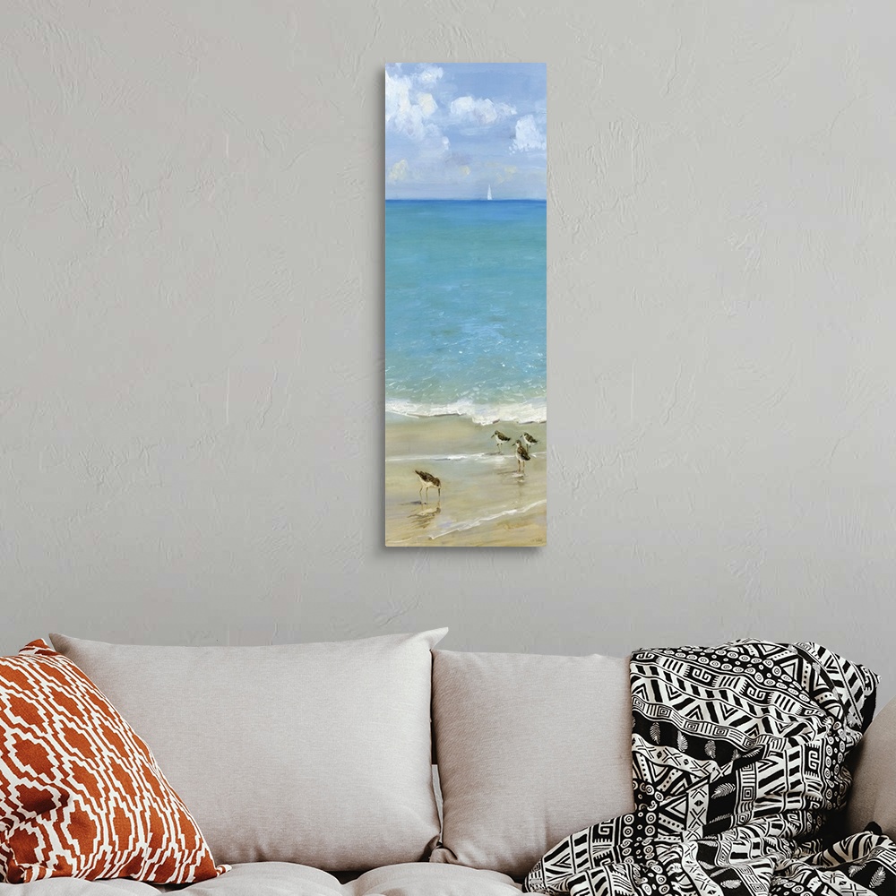 A bohemian room featuring Tall contemporary painting of seabirds on the shore with blue water and a sailboat in the backgro...