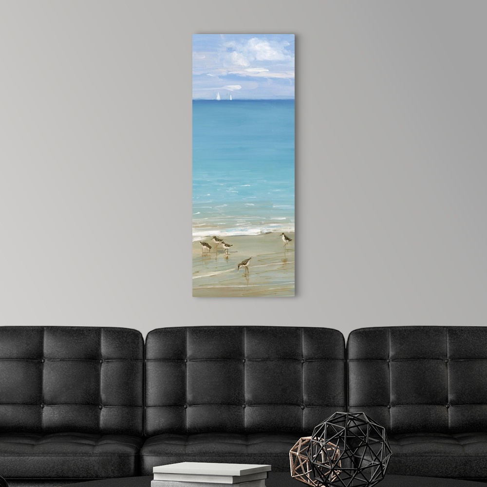 A modern room featuring Tall contemporary painting of seabirds on the shore with blue water and sailboats in the background.