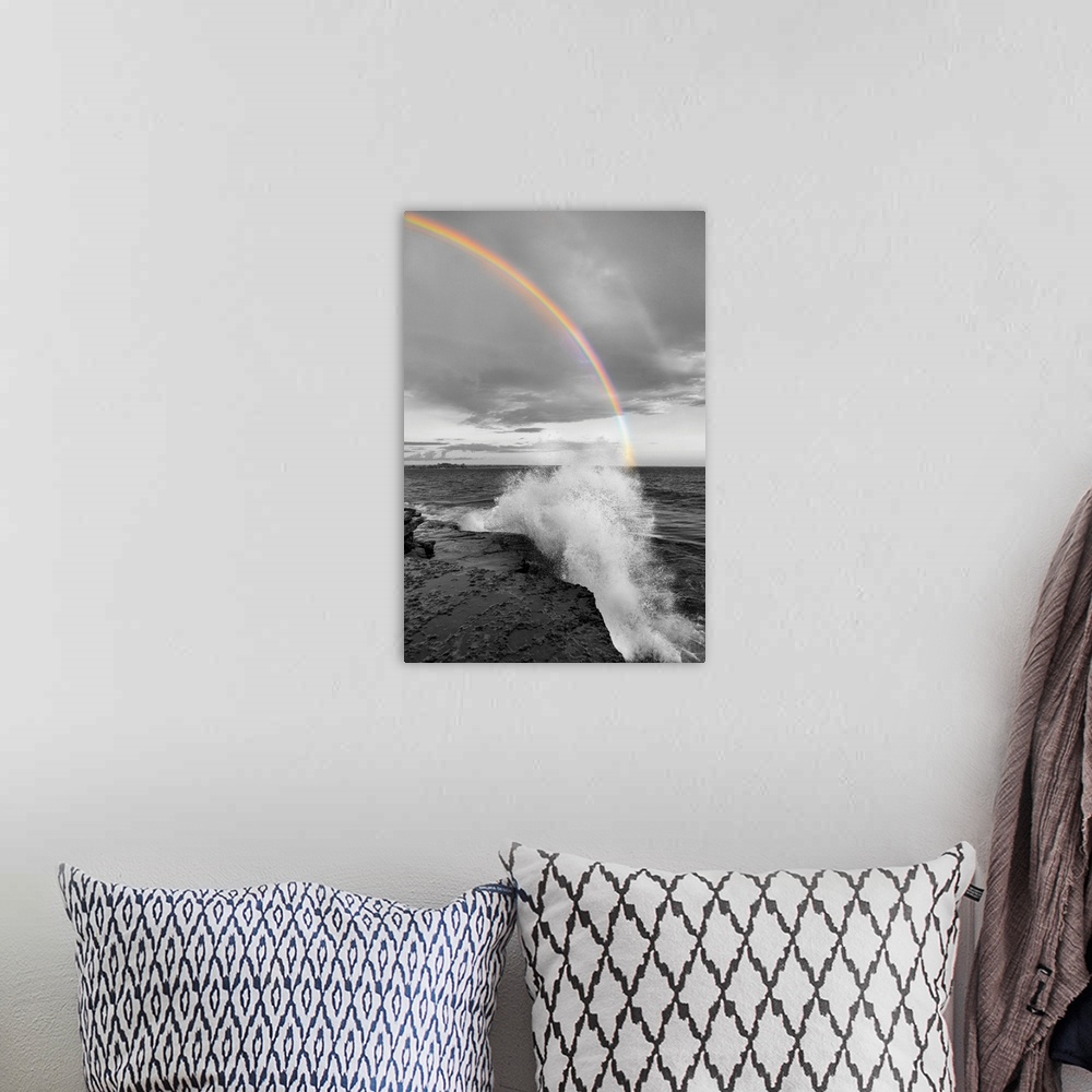 A bohemian room featuring Black and white photograph of a waves crashing on a rocky shore with a colorful rainbow over the ...