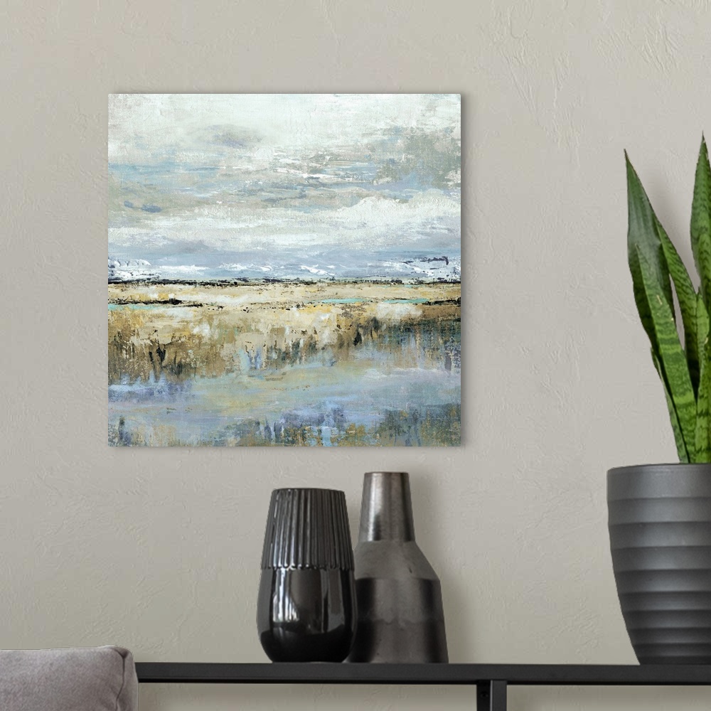 A modern room featuring Square abstract painting of a marsh landscape in shades of brown, blue, yellow, and grey.