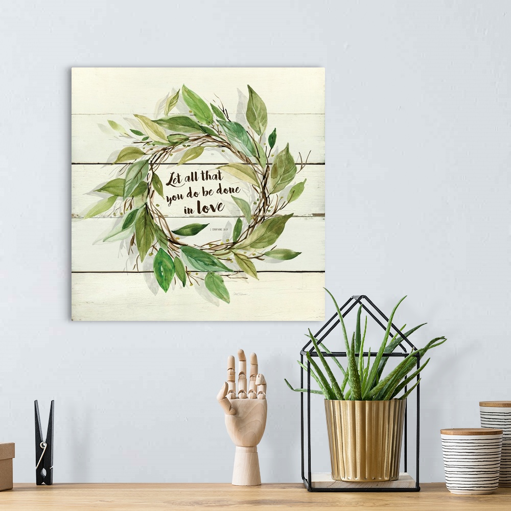 A bohemian room featuring A watercolor painting of a wreath with green leaves on a wood background and the verse ?Let all t...