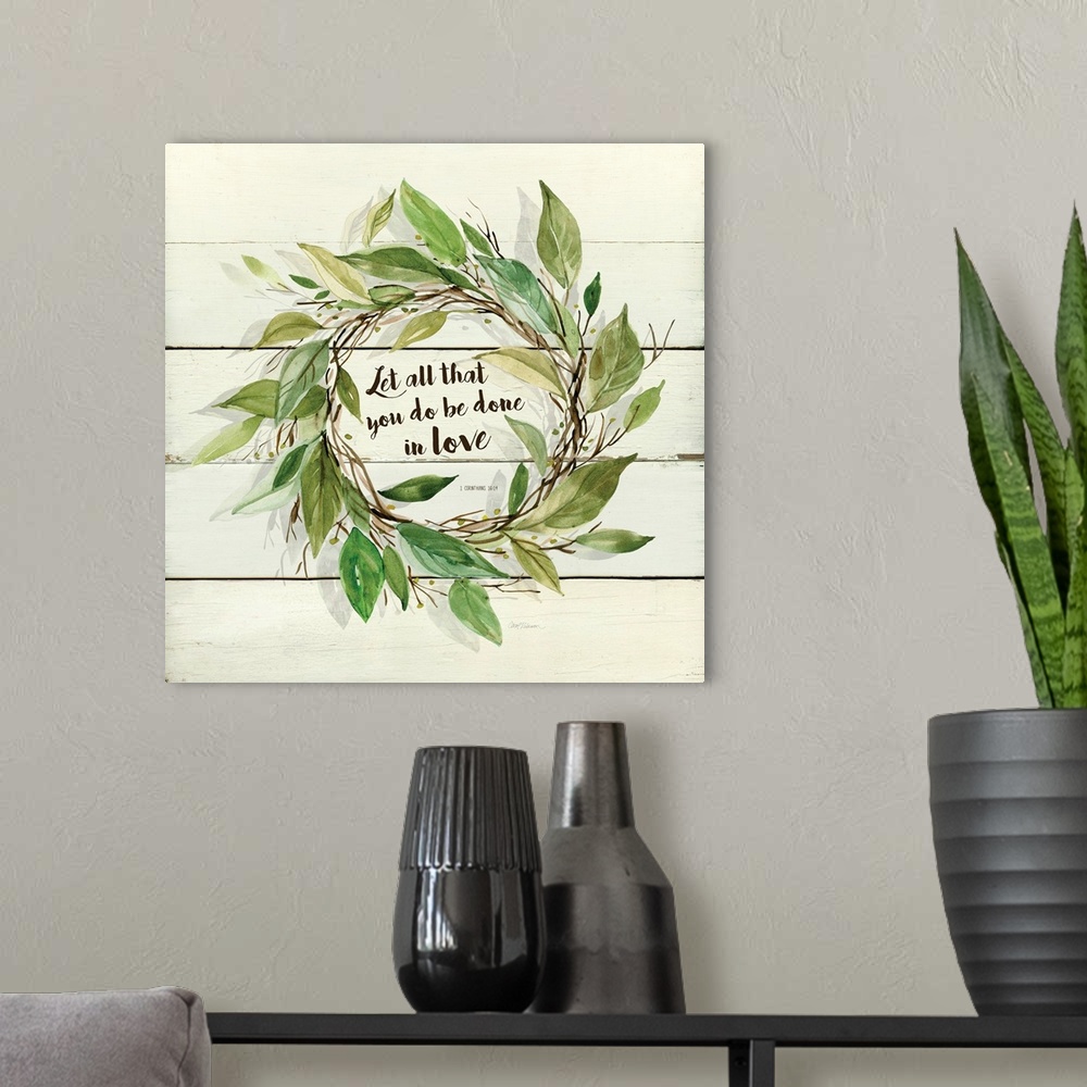 A modern room featuring A watercolor painting of a wreath with green leaves on a wood background and the verse ?Let all t...