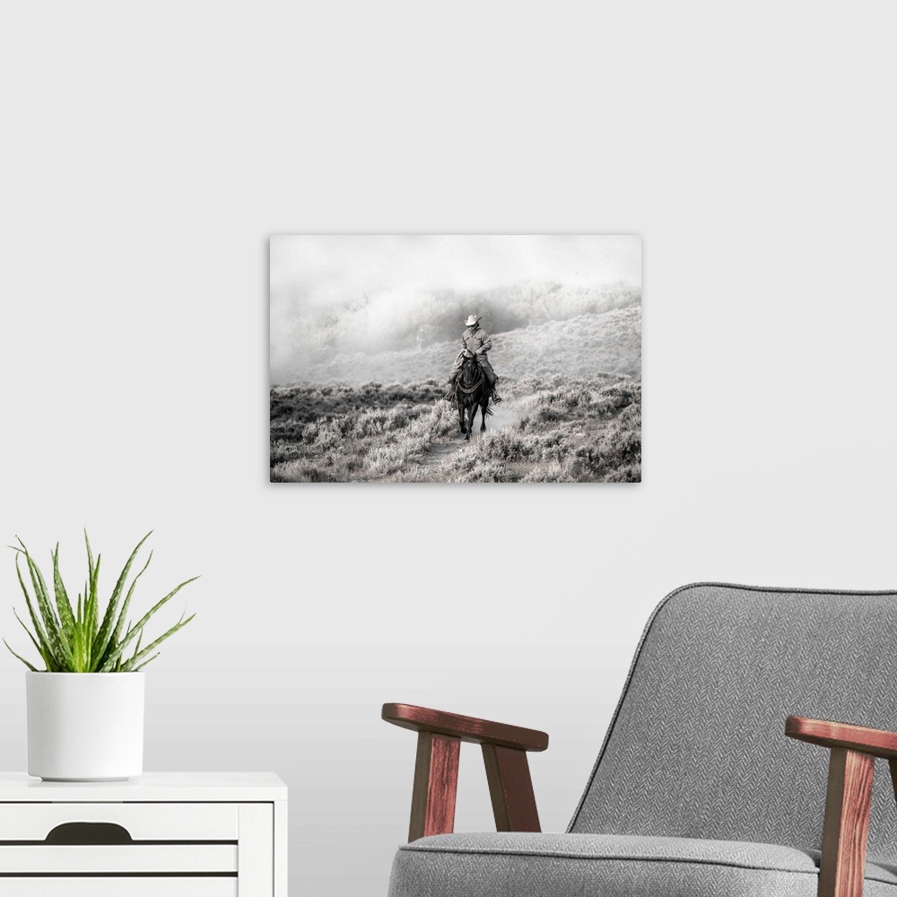 A modern room featuring Lone wrangler riding back from herding horses.