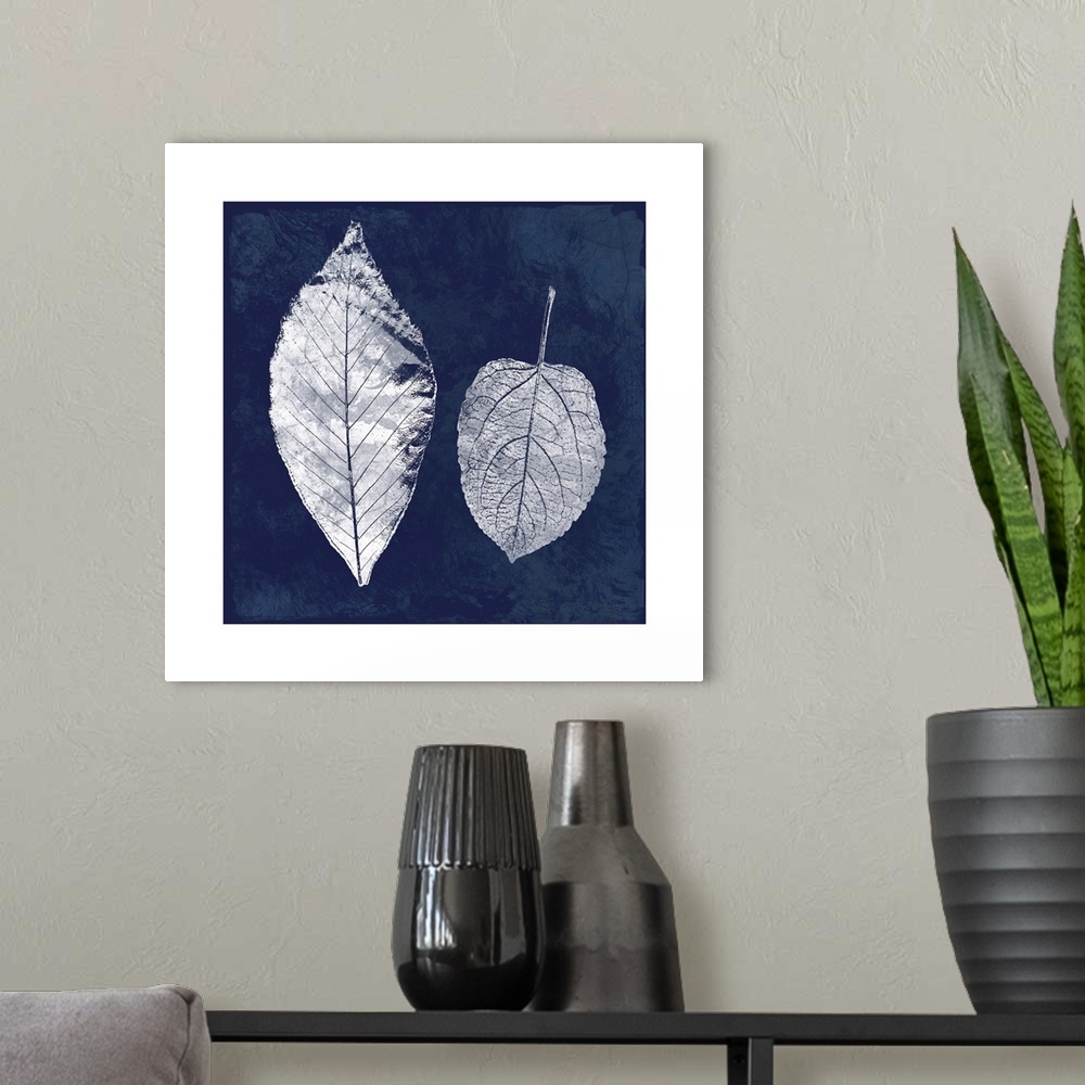 A modern room featuring Square cyanotype of white silhouetted leaves on an indigo background with a white boarder.