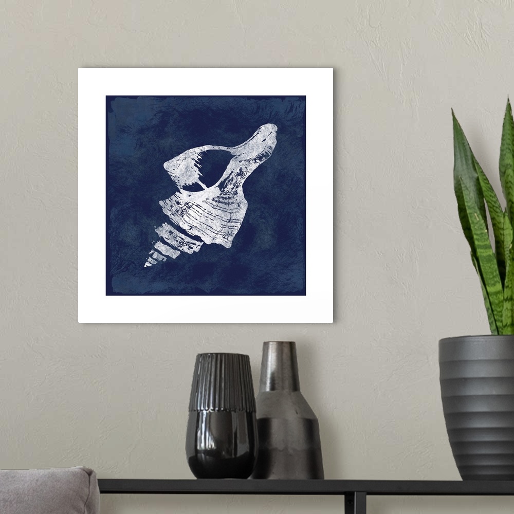 A modern room featuring Square cyanotype of a white silhouetted seashell on an indigo background with a white boarder.