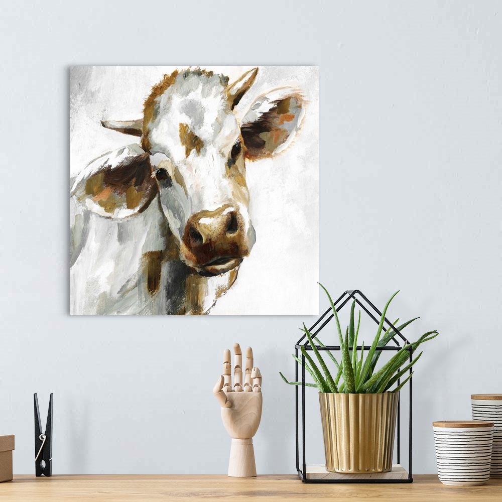 A bohemian room featuring Square painting of a brown, grey, and white cow.