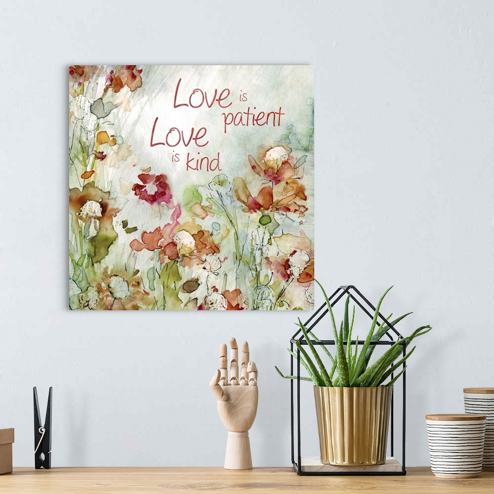 A bohemian room featuring Decorative watercolor artwork of a group of flowers with the text "Love is Patient, Love is Kind".