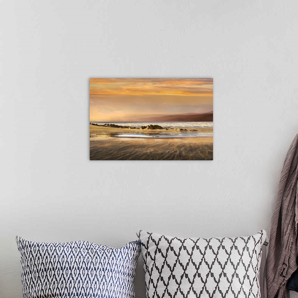 A bohemian room featuring Landscape photograph of a warm toned sunset over a beach at low tide.
