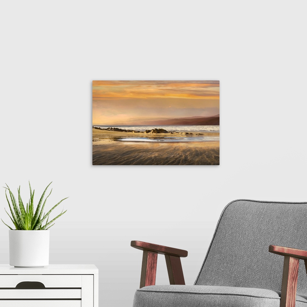 A modern room featuring Landscape photograph of a warm toned sunset over a beach at low tide.