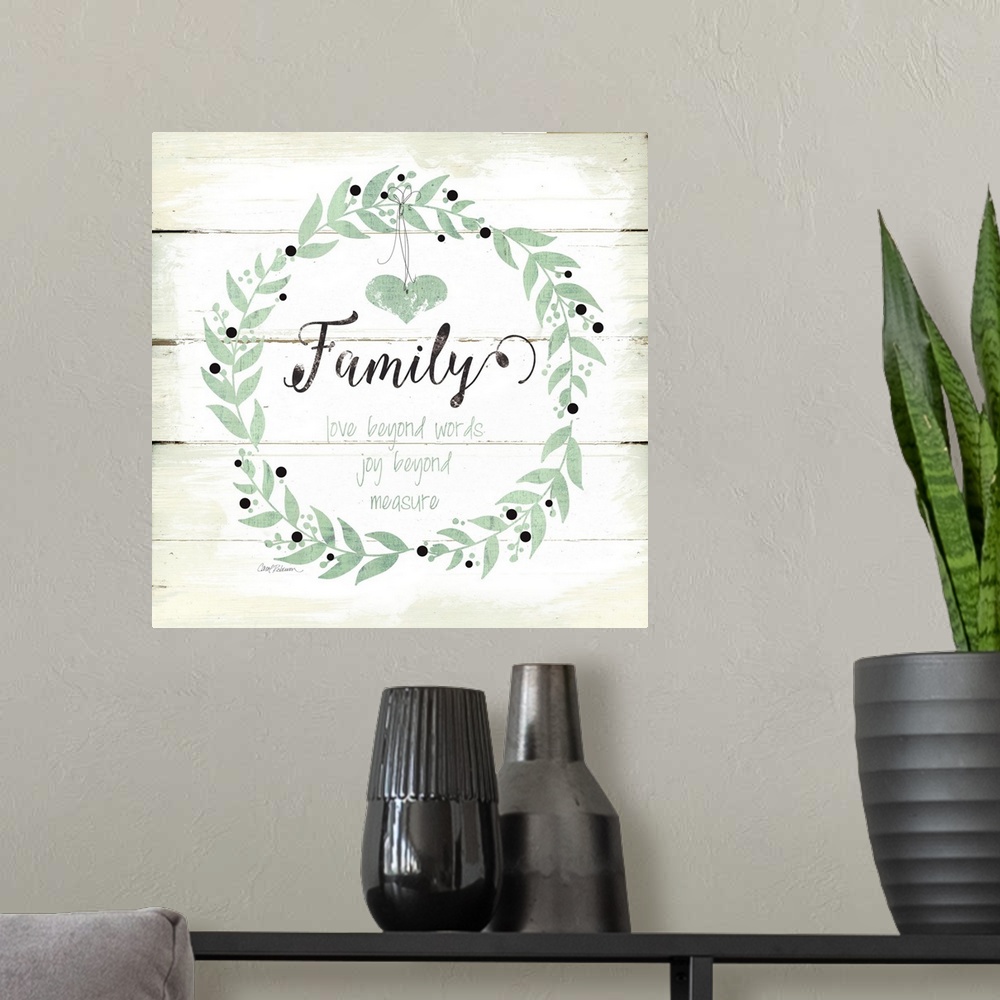 A modern room featuring A decorative painting of a wreath on an aged white wooden background with the word ?Family? paint...
