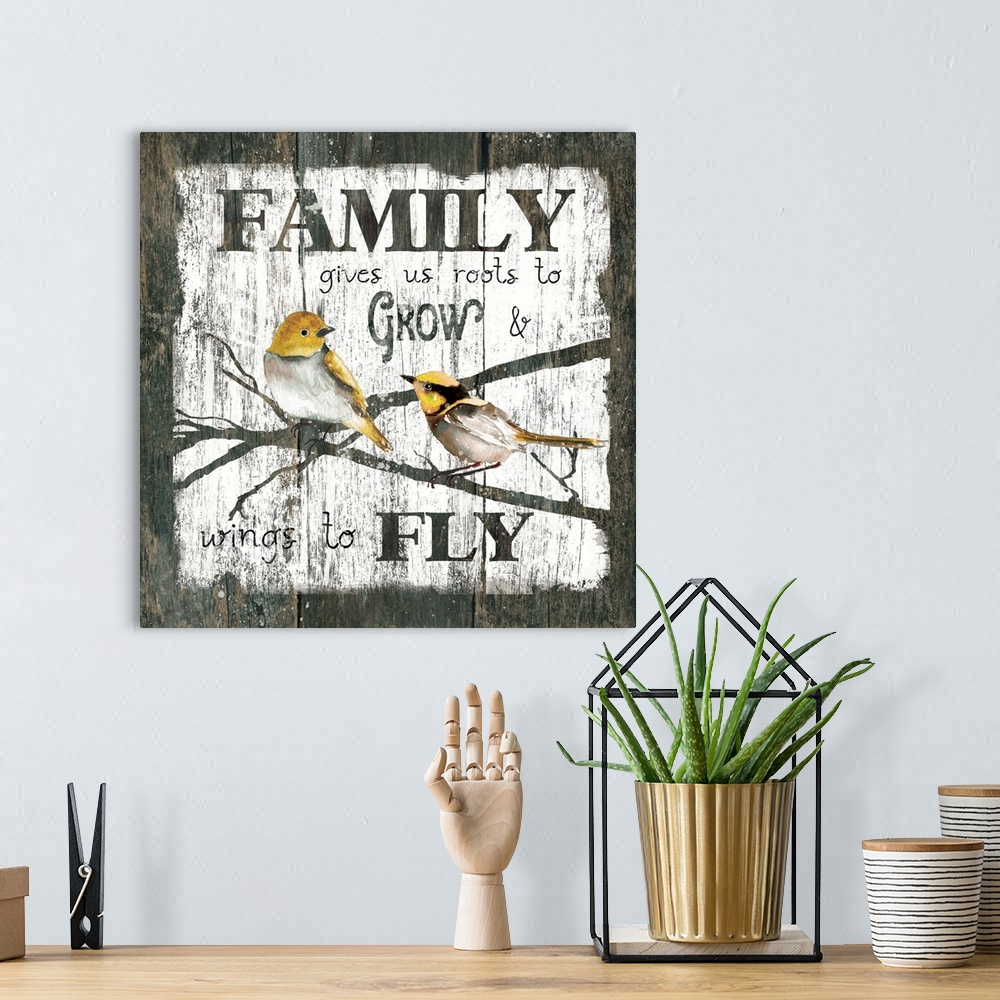 A bohemian room featuring A decorative painting of two birds sitting on branches and the text ?Family gives us roots to Gro...