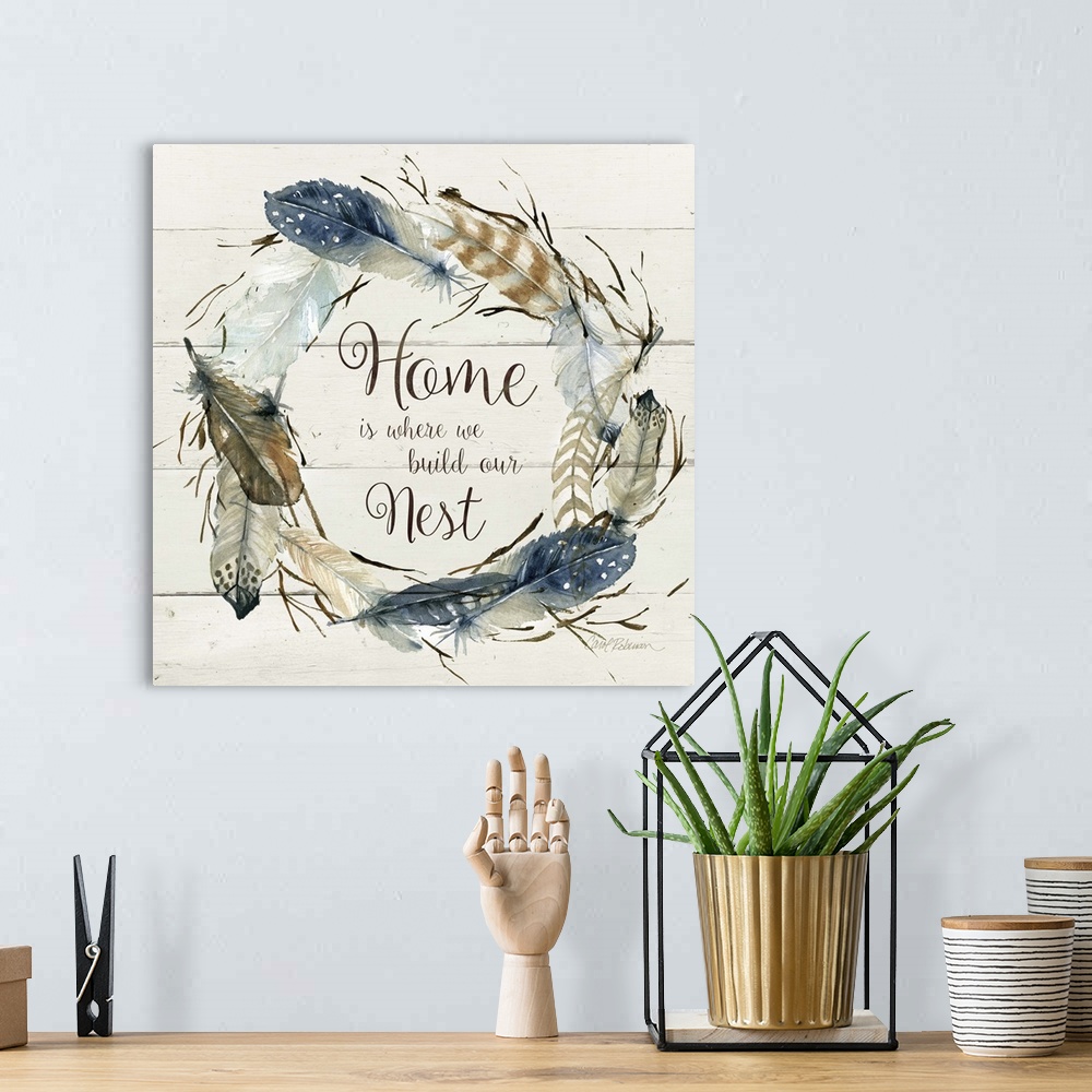A bohemian room featuring Square watercolor painting with a wreath made of feathers and the phrase "Home is Where We Build ...