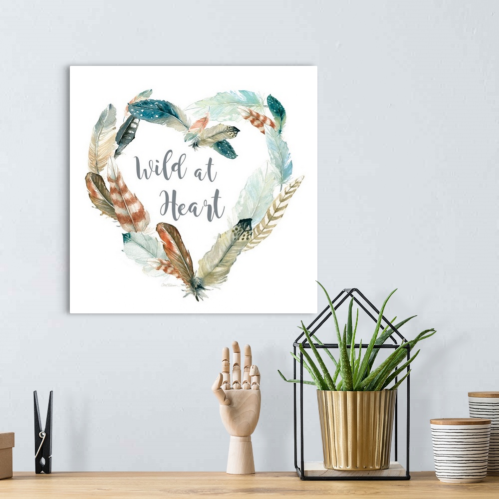 A bohemian room featuring Square watercolor painting with a heart shaped wreath made of feathers and the phrase "Wild at He...