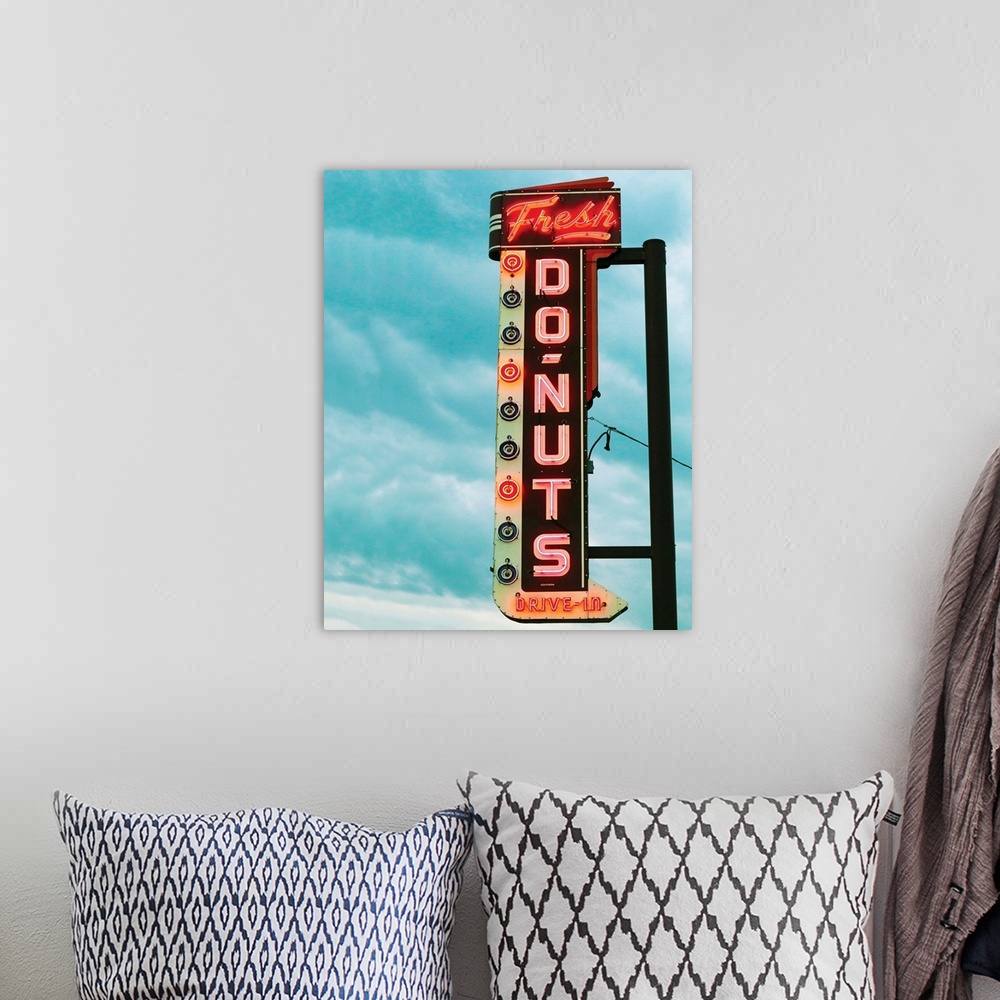 A bohemian room featuring Photograph of a vintage 'Fresh Doughnut' neon sign with a cloudy blue sky in the background.
