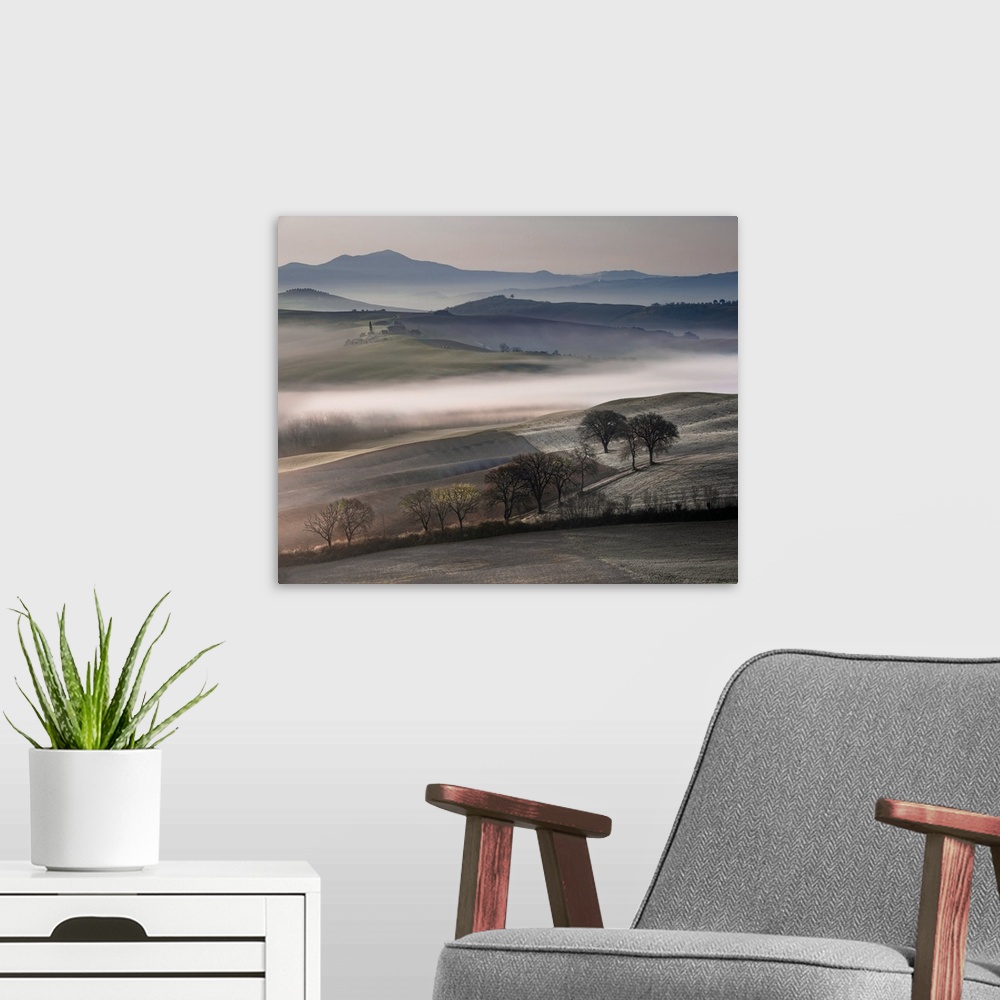 A modern room featuring Photograph of rolling fields covered in mist with mountains in the background.