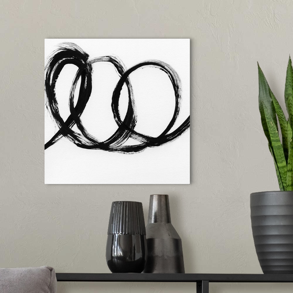 A modern room featuring Square black and white abstract painting with a thick, bold, loopy line.