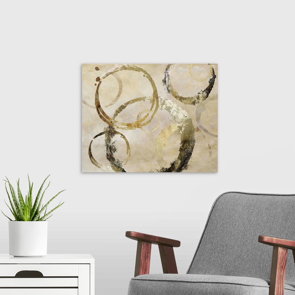 A modern room featuring Geometric abstract painting with distressed golden, dark gray and beige rings against a neutral t...