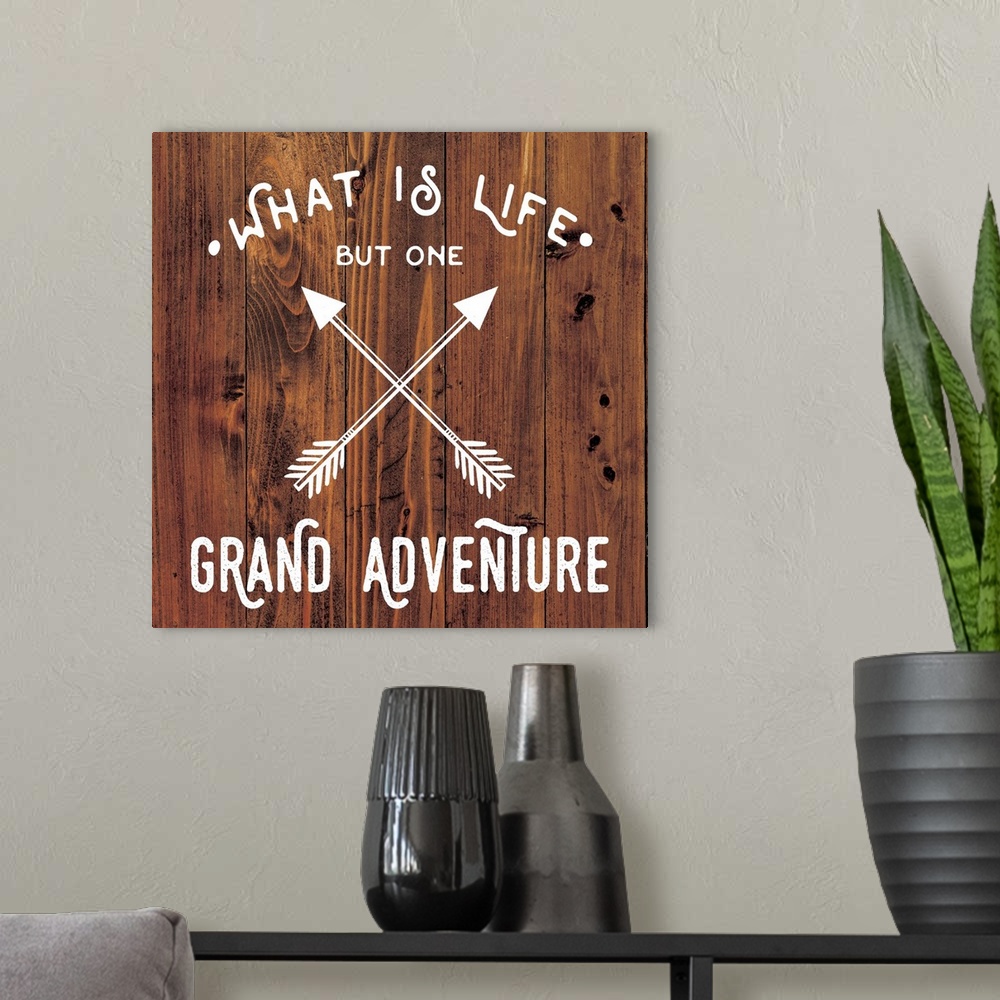 A modern room featuring Typography art reading "What is life but one grand adventure" with a crossed arrow design on a wo...