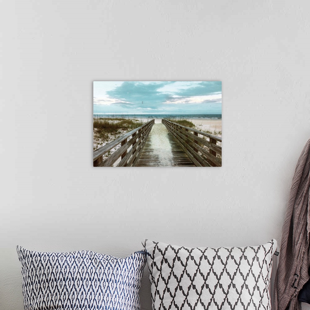A bohemian room featuring A photo of a boardwalk leading to a sandy unoccupied beach.