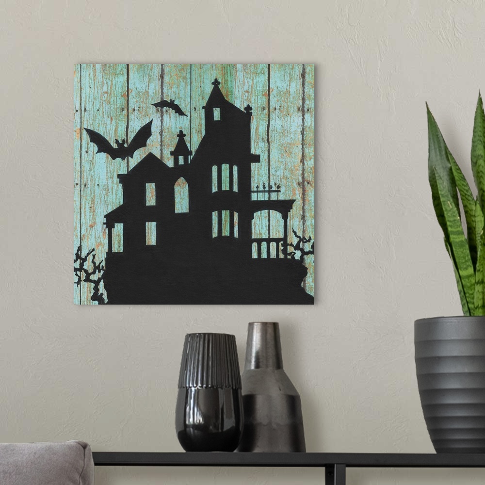 A modern room featuring A decorative Halloween painting of a haunted house with two bats flying around it on an aged, blu...