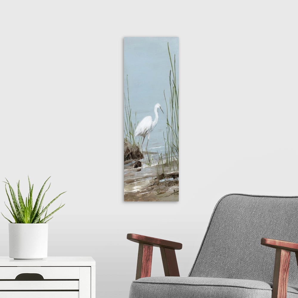 A modern room featuring Tall panel painting of an egret on a rocky shore with tall beach grass.