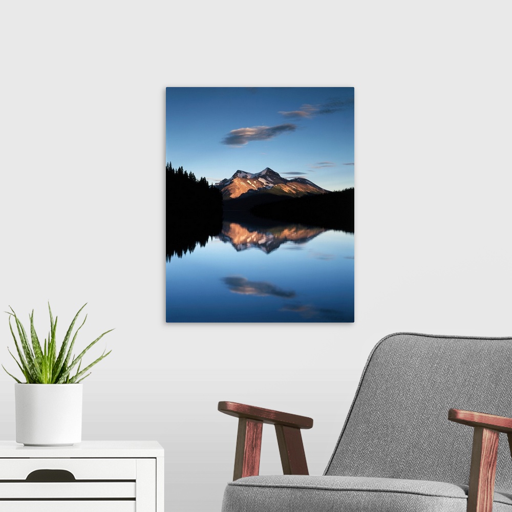 A modern room featuring Clouds and sunset light on the mountains reflected in the lake below in Jasper National Park, Alb...