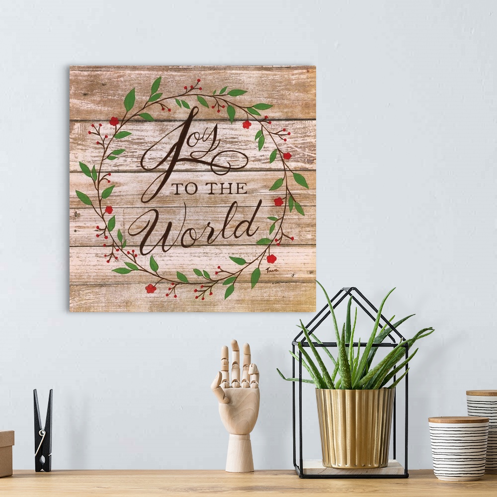 A bohemian room featuring ?Joy to the World? handwritten inside a wreath on a wooden background.�