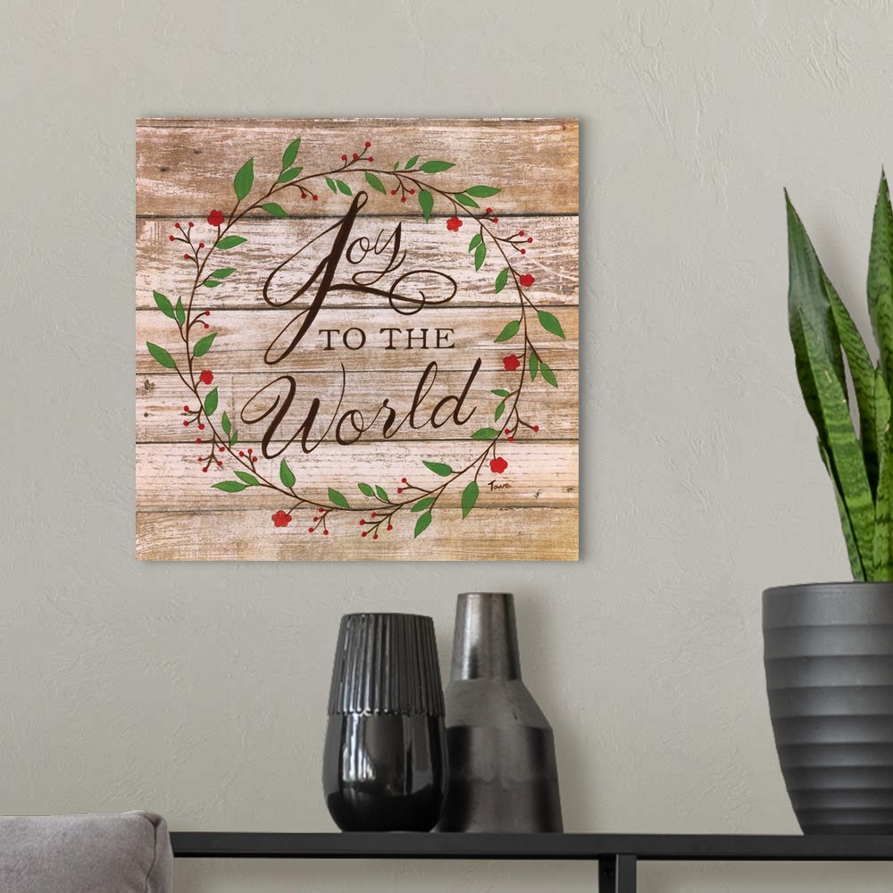 A modern room featuring ?Joy to the World? handwritten inside a wreath on a wooden background.�
