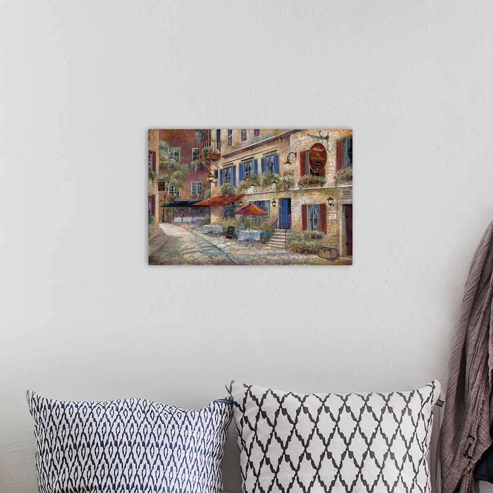 A bohemian room featuring Contemporary art print of the facade of street cafes in rural France.