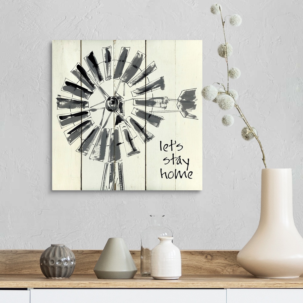 A farmhouse room featuring 'Let's Stay Home' written on a square shiplap background with an illustration of a windmill.
