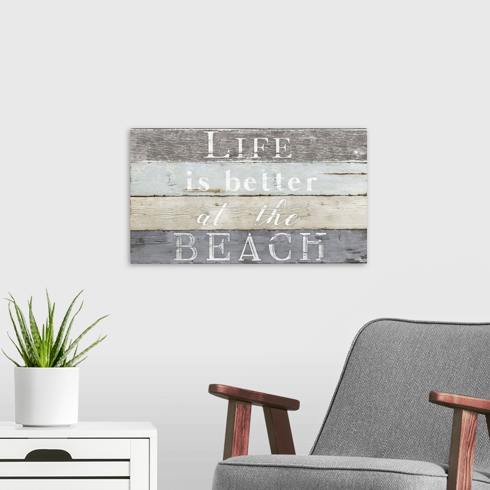 A modern room featuring Decorative artwork with the text "Life is Better at The Beach" against a wood plank backdrop.
