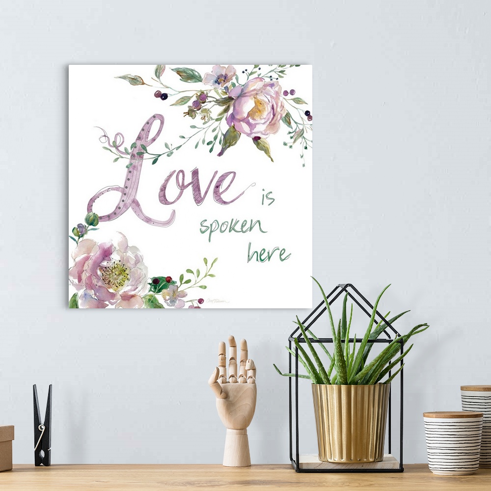 A bohemian room featuring "Love is Spoken Here" with water color flowers.